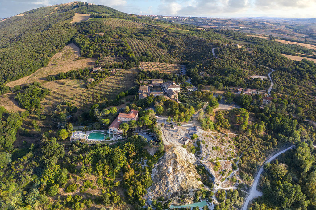 heuvels met wijn- en olijfgaarden en een landgoed met zwembad in Toscane, Italië.