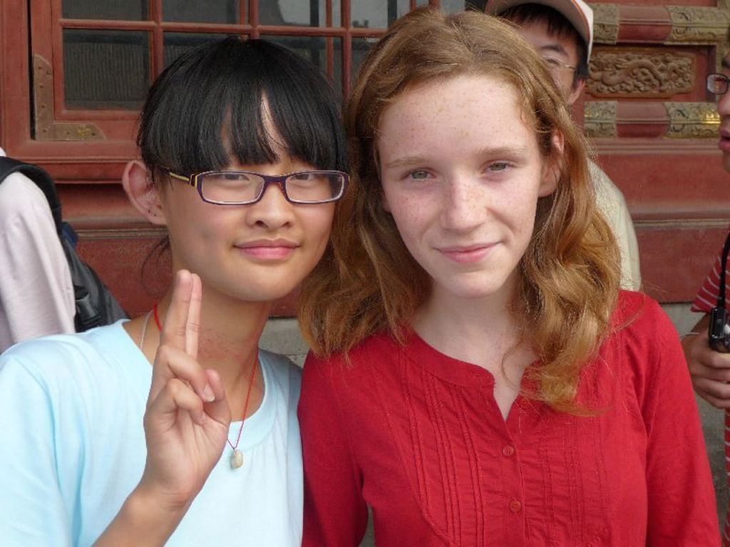 Twee meisjes poseren samen tijdens een familiereis in China.