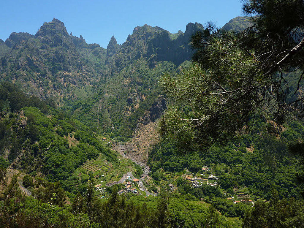 Groen berglandschap op Madeira met diep dal en dorpjes, tijdens een wandelvakantie.