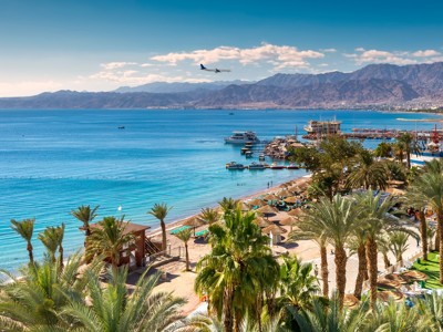Strand en jachthaven van Eilat aan de Rode Zee, met bergen op de achtergrond.