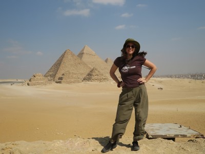 Reiziger bij de piramides van Gizeh tijdens Route Egypte, met woestijn en blauwe lucht op de achtergrond.
