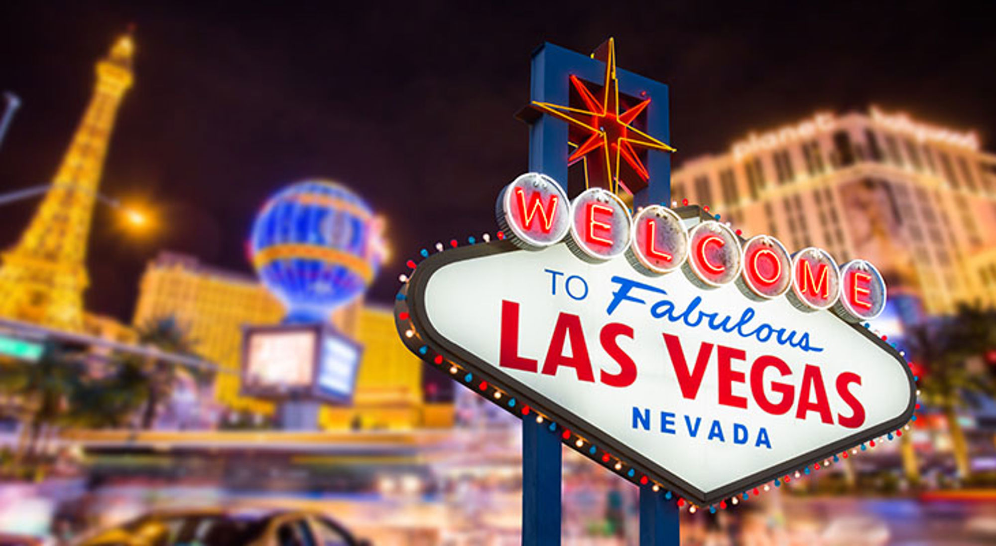 Verlicht “Welcome to Fabulous Las Vegas Nevada”-bord met de Las Vegas Strip op de achtergrond.