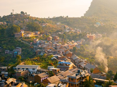 Heuveldorp met terrassen en huizen in de ochtendzon tijdens de Route Nepal.