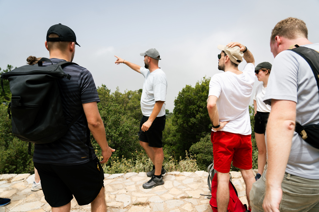 22-35ers groepsreis Albanië: groep wandelaars luistert naar reisleider die de route aanwijst bij een uitzichtpunt.