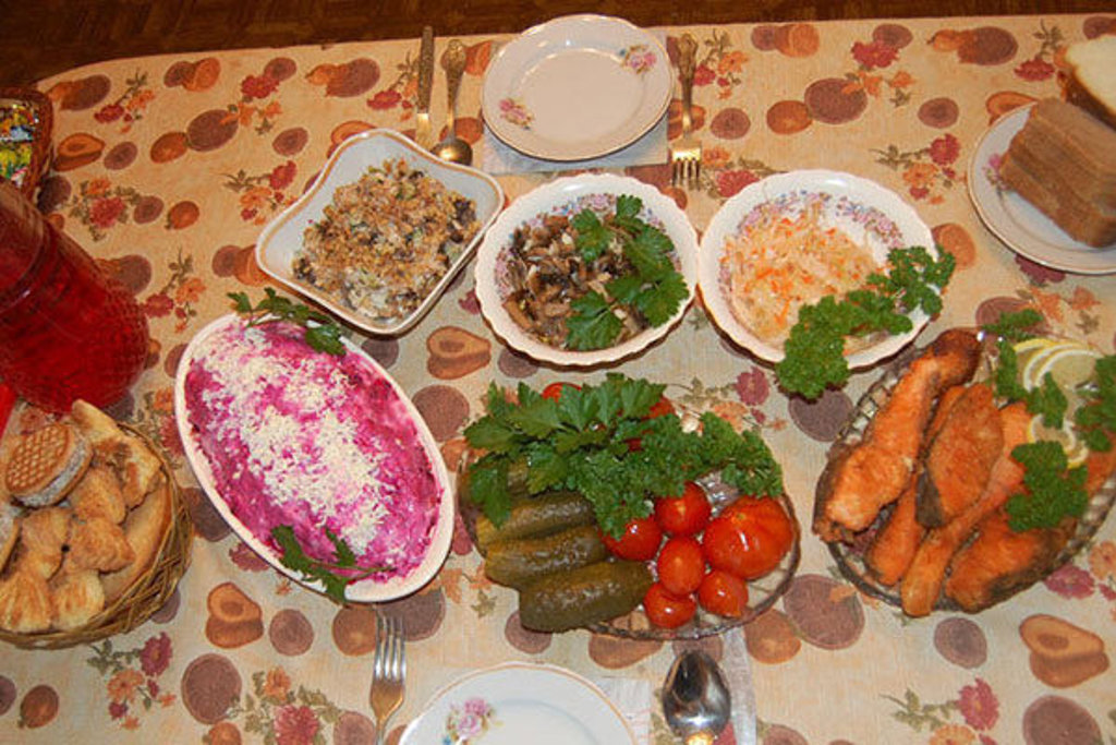 Russische maaltijd met zalm, augurken, salades en brood op tafel tijdens groepsrondreis Rusland winter.