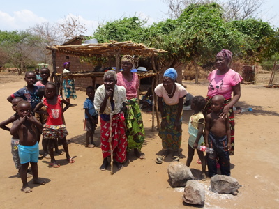 Lokale bewoners en kinderen bij een dorpshuis in Zimbabwe tijdens de 22-daagse reisroute.