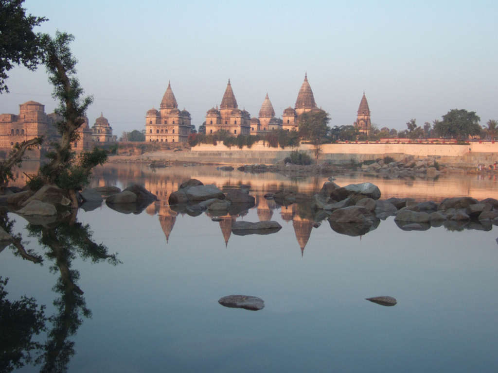 Tempels en paleizen aan de rivier in Orchha, India, weerspiegeld in het water.