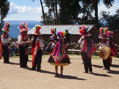 Traditionele dansers in kleurrijke klederdracht tijdens een festival aan het Titicacameer op de Route Peru.