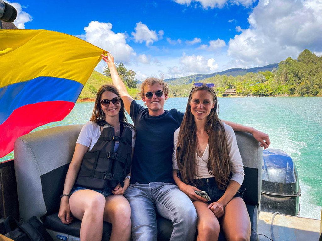 22-35ers genieten van een boottocht op een meer in Colombia met de Colombiaanse vlag.