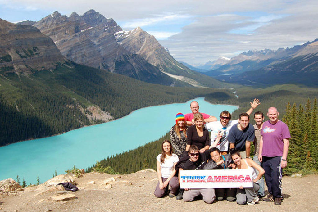 Groepsfoto van reizigers bij een turquoise bergmeer in de Canadese Rocky Mountains tijdens rondreis Canada West.