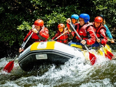 Raften op een rivier in de Pyreneeën tijdens Route Canigou, met helmen en reddingsvesten.