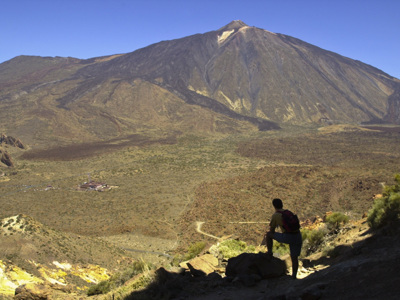 Wandelaar met rugzak kijkt uit op de vulkaan El Teide op Tenerife tijdens de wandelvakantie Tenerife & La Palma.