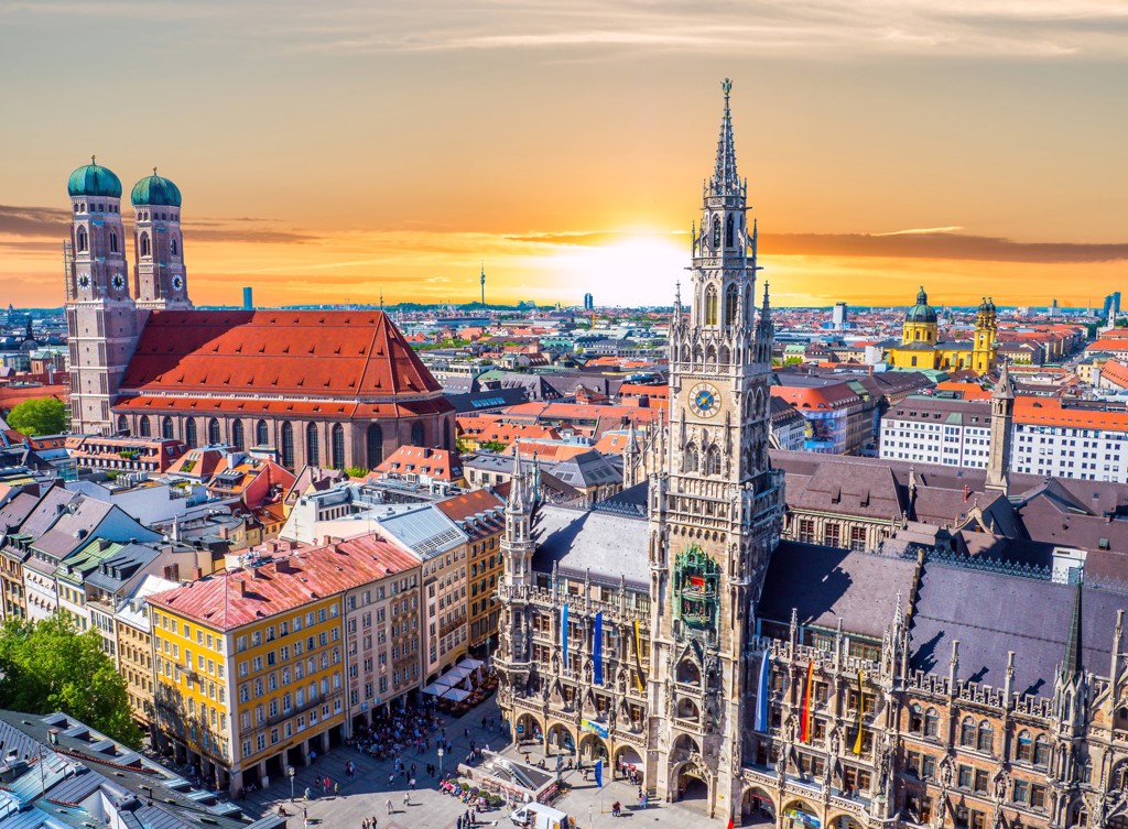 Uitzicht over het Marienplatz met het Neues Rathaus en de Frauenkirche in München tijdens zonsondergang.