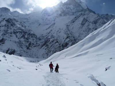Wandelaars op de besneeuwde Annapurna-trektocht in Nepal, met hoge bergtoppen op de achtergrond.