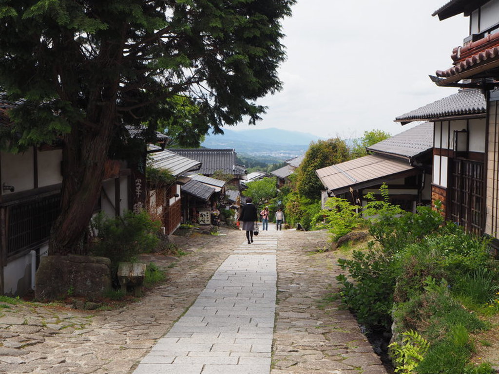 Traditionele straat in Japan met houten huizen langs een stenen pad, gezien tijdens groepsrondreis Japan hoogtepunten.