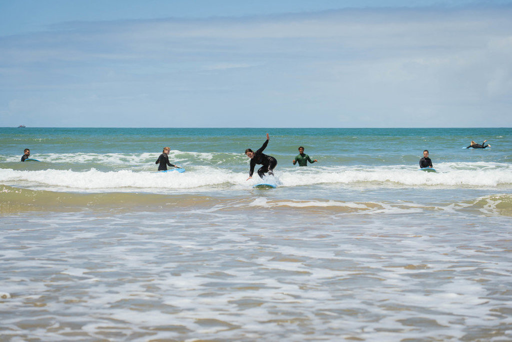 Surfers in wetsuits oefenen in de golven aan de Atlantische kust tijdens een 22-35ers reis Marokko.