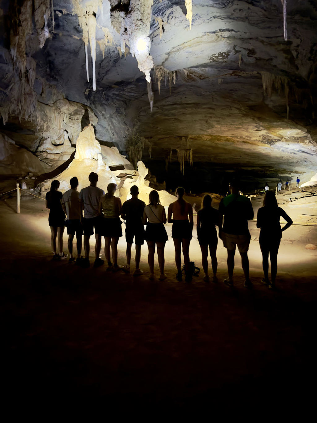 Groep reizigers tijdens een 22-35ers reis door Brazilië in een grot met stalactieten en stalagmieten.