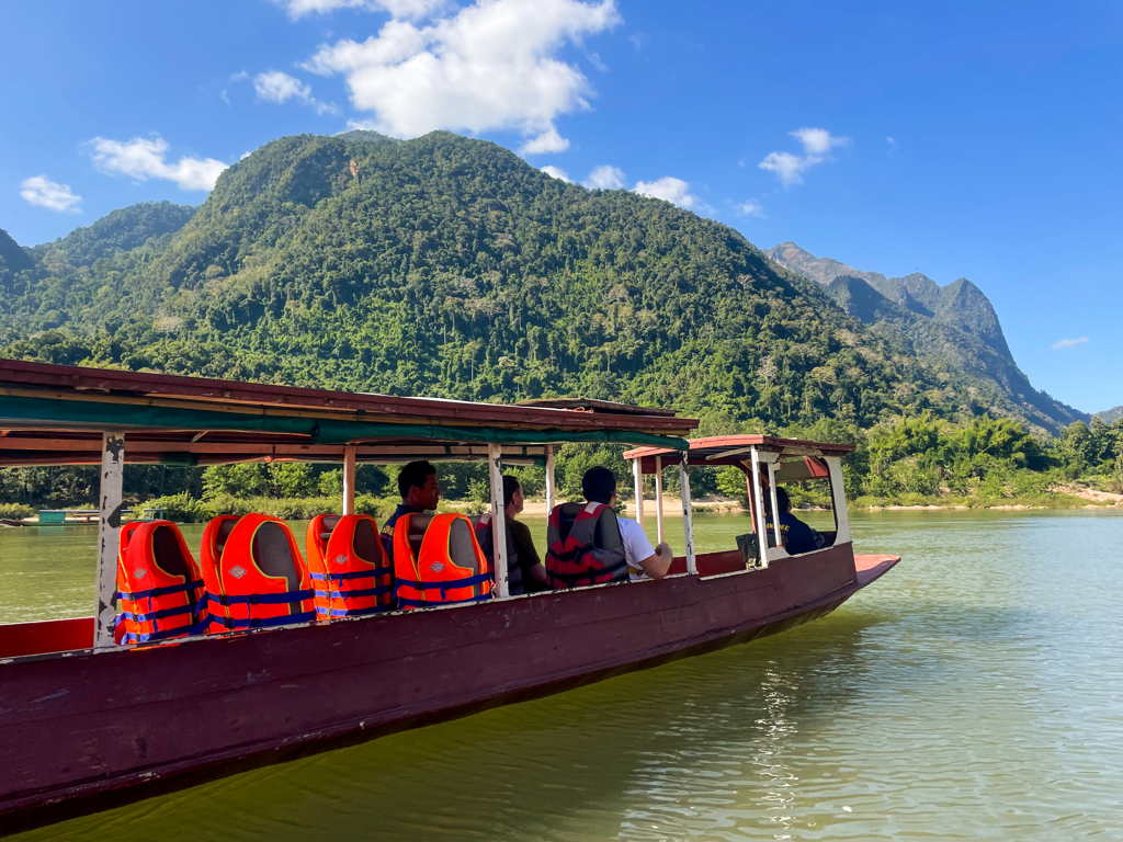 Boottocht op de Mekong in Laos met uitzicht op groene bergen tijdens 22-35ers reis Thailand, Laos & Cambodja.