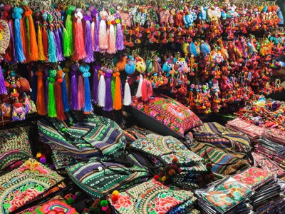 Kleurrijke markt in Thailand met handgemaakte tassels, sleutelhangers en geborduurde tassen en kussens.