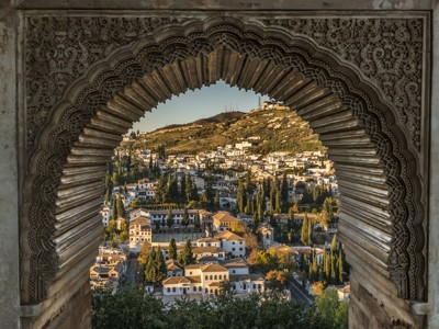 Uitzicht op de wijk Albaicín in Granada door een Moorse boog van het Alhambra.