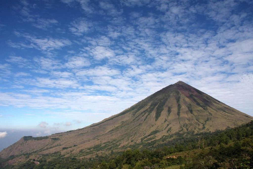 Vulkaanlandschap op de Kleine Sunda eilanden in Indonesië, met groene hellingen onder een blauwe lucht.