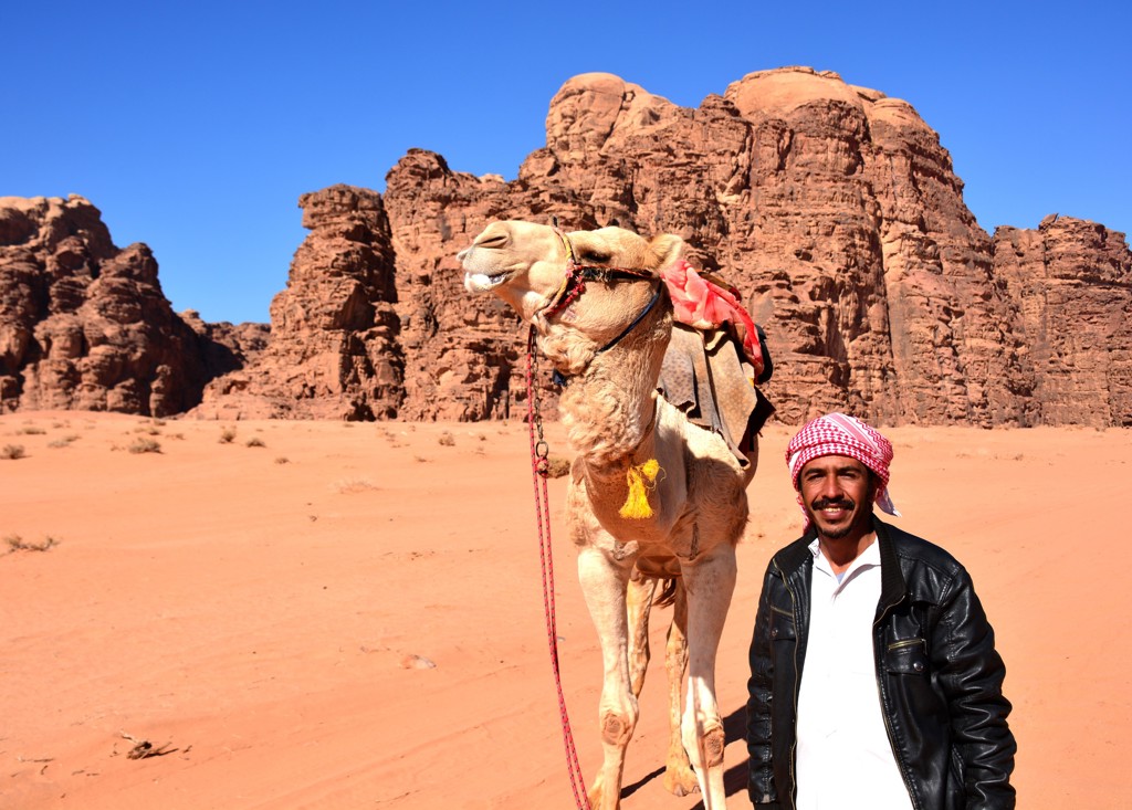 Kameel met gids in de Wadi Rum-woestijn, Jordanië, tijdens groepsrondreis Israël en Jordanië.