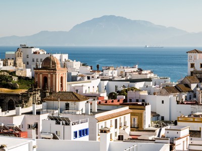 Witgekalkte huizen in Tarifa met uitzicht op de Straat van Gibraltar en de bergen van Marokko.
