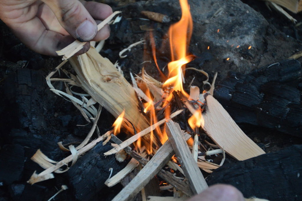 Kampvuur maken met houtspaanders tijdens een groepsrondreis in Lapland, Finland in de zomer.