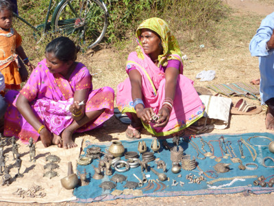 Vrouwen verkopen handgemaakte sieraden en metalen beeldjes op een markt in Odisha tijdens Route Orissa, 23 dagen.