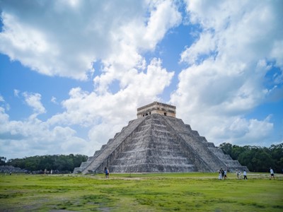 Piramide El Castillo in Chichén Itzá tijdens de familiereis Mexico, onder een blauwe lucht met wolken.