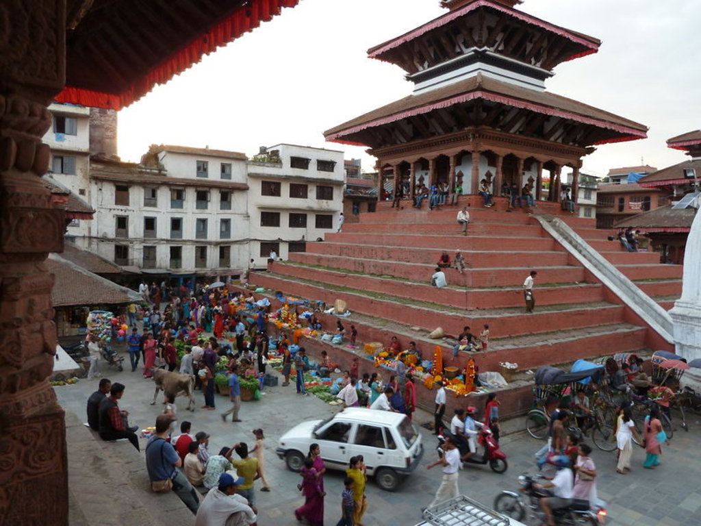 Drukke markt op Durbar Square in Kathmandu, Nepal, met pagodetempel en trappen.