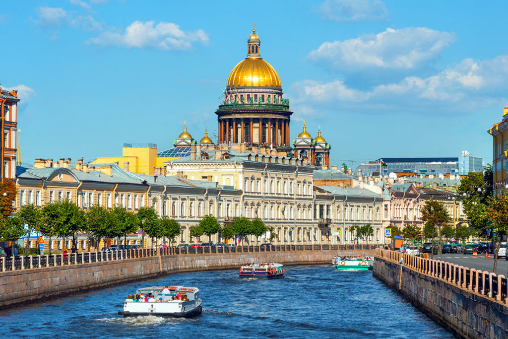Sint-Isaäkkathedraal in Sint-Petersburg met rondvaartboten op het kanaal.