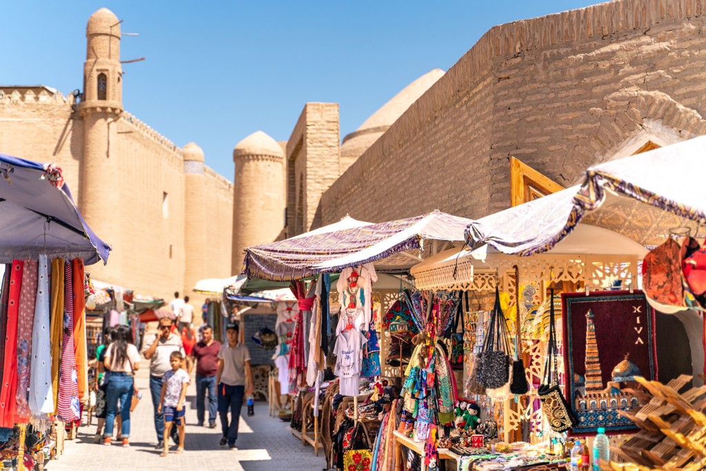 Markt met kleurrijke souvenirs bij de oude stadsmuur van Khiva in Oezbekistan tijdens een groepsrondreis.