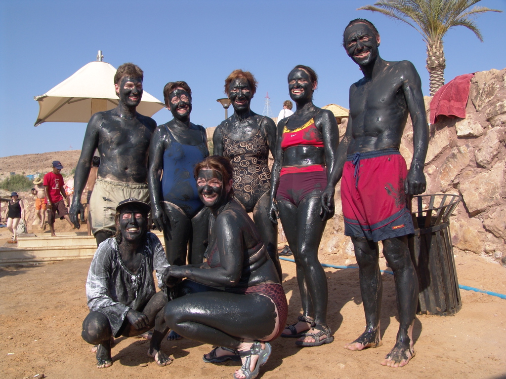 Reizigers bedekt met zwarte modder bij de Dode Zee tijdens een groepsrondreis Jordanië.