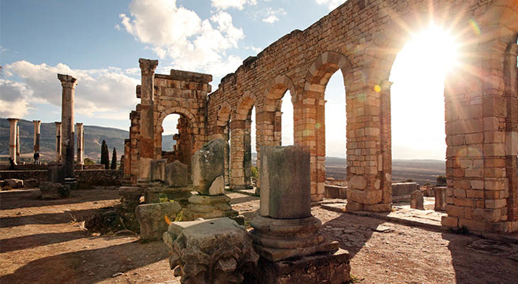 Meknes Romeinse ruïnes van Volubilis in Marokko, met stenen bogen en zuilen in de zon.