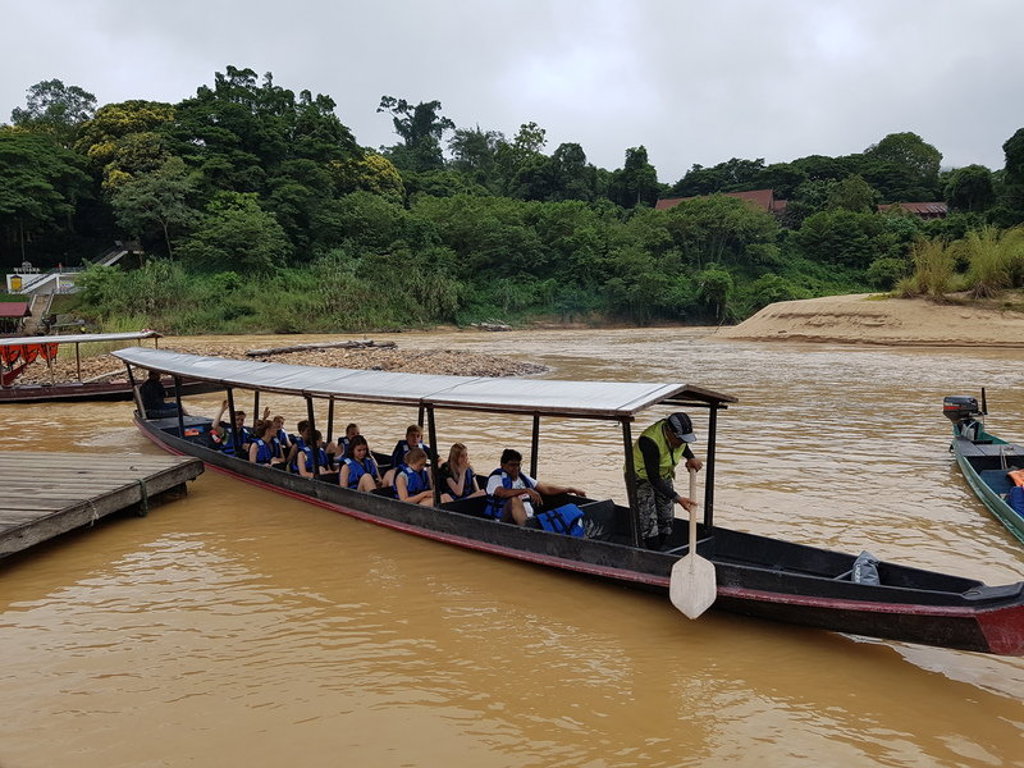 Boottocht over een rivier in de Maleisische jungle tijdens een familiereis, met passagiers in reddingsvesten.