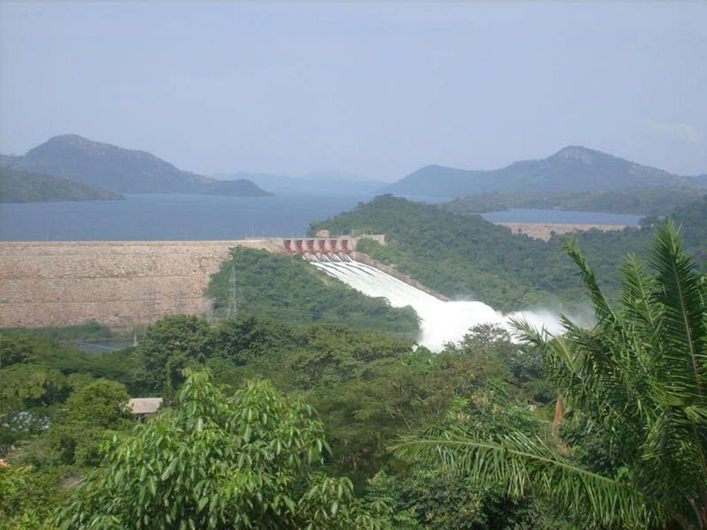 Uitzicht op de Akosombo-dam en het Volta-meer in Ghana, omringd door groene heuvels.
