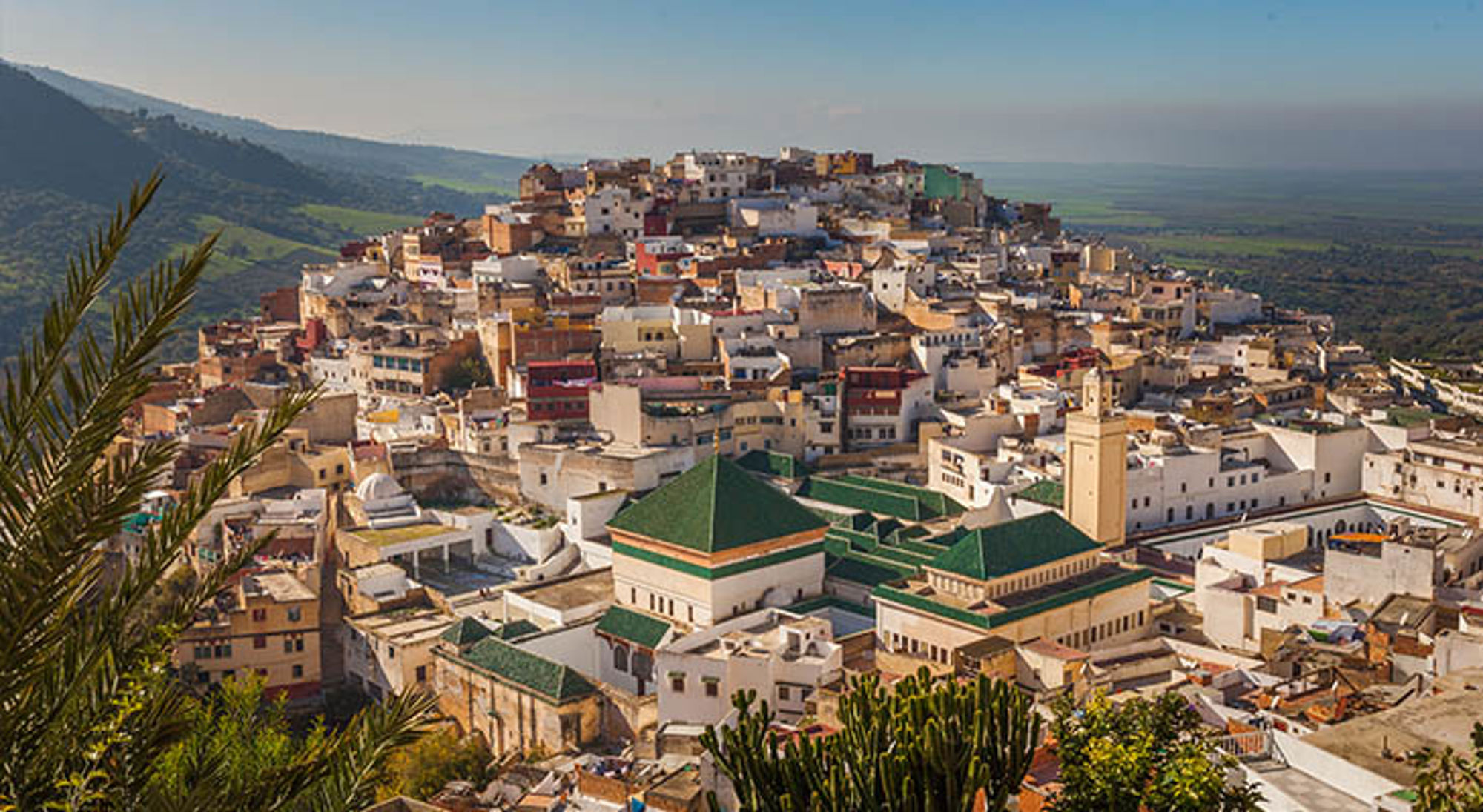 Moulay Idriss Panoramisch uitzicht op Moulay Idriss, Marokko, met witte huizen en moskeeën op een heuvel.