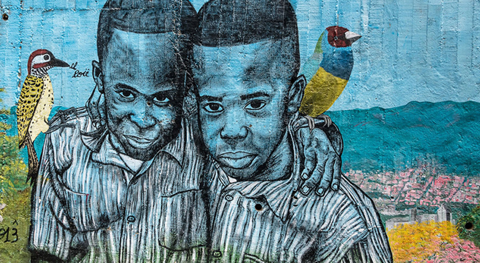 Puur Sawadee projecten Colombia Muurschildering van twee jongens met vogels op een blauwe achtergrond.