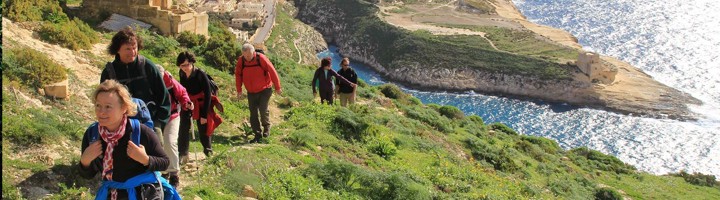 Wandelaars op kustpad langs de rotsen en een baai op Malta.
