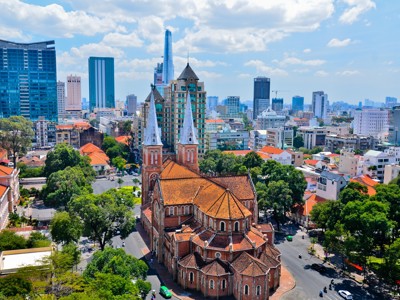 Notre-Dame kathedraal in Ho Chi Minhstad met skyline op de achtergrond, Vietnam.