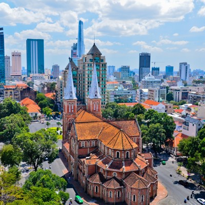 Notre-Dame kathedraal in Ho Chi Minhstad met skyline op de achtergrond, Vietnam.