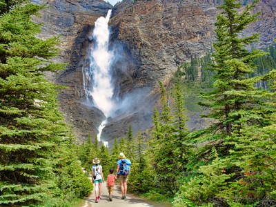 Wandelaars op bospad richting waterval in de Canadese Rockies tijdens Route Canada.