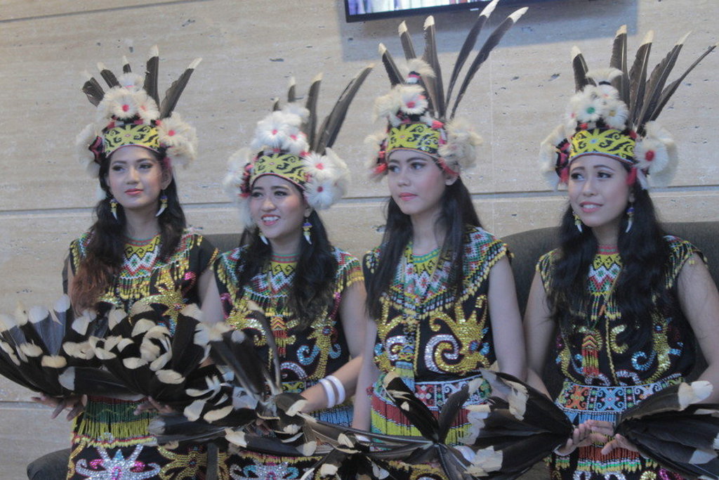 Traditionele dansers in kleurrijke klederdracht met veren hoofdtooien tijdens de groepsrondreis Kalimantan, Sulawesi & Molukken.