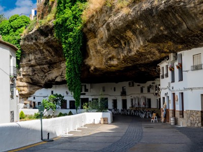 Witte huizen onder een rotswand in Setenil de las Bodegas, Andalusië.