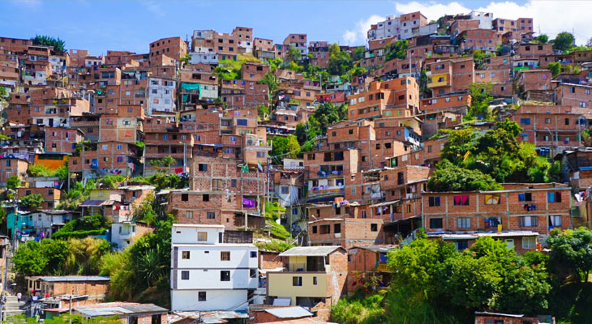 Sloppenwijk Medellín Dichtbebouwde wijk met kleurrijke huizen op een heuvel in Colombia.