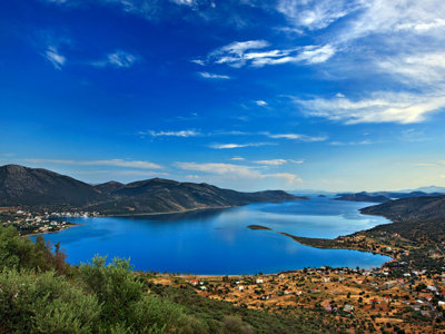 Uitzicht over een blauwe baai met bergen en dorpjes op Evia, Griekenland.