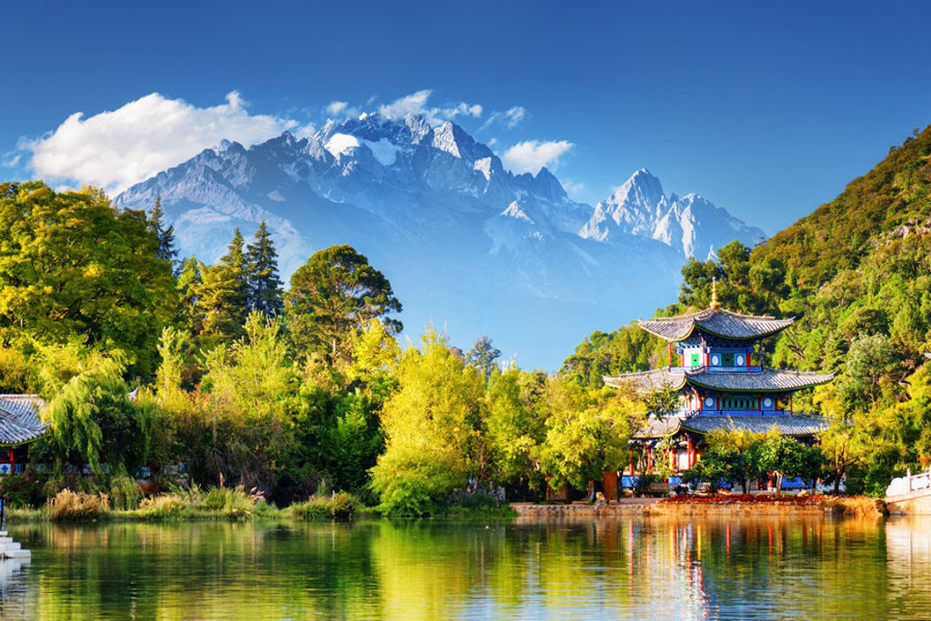 Traditionele Chinese pagode aan een meer met bergen op de achtergrond tijdens groepsrondreis China.