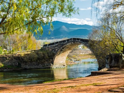 Stenen boogbrug over de rivier in Shaxi, Yunnan, tijdens Route China 32 dagen.