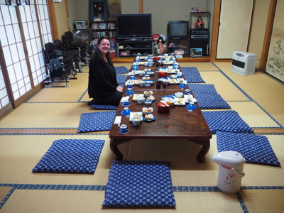 Japanse ryokan-maaltijd op lage tafel met zitkussens op tatami, klaar voor diner.